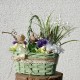 proutěný zelenkavý košík aranžovaný umělými  jarními květy konvalinek a krokusů  doplněno větvičkami kroucené lísky,  ptáčky